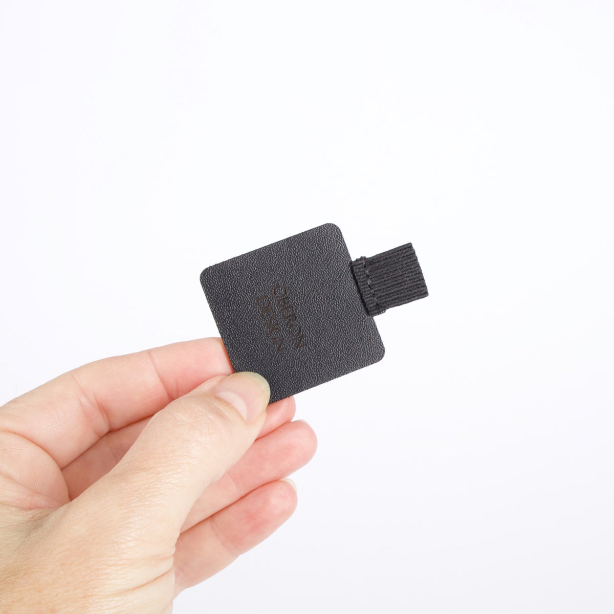 Leather and elastic Self-adhesive Pen Loop, in hand, by Oberon Design