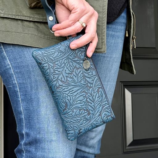 Leather acanthus navy zip writslet model in front of door 