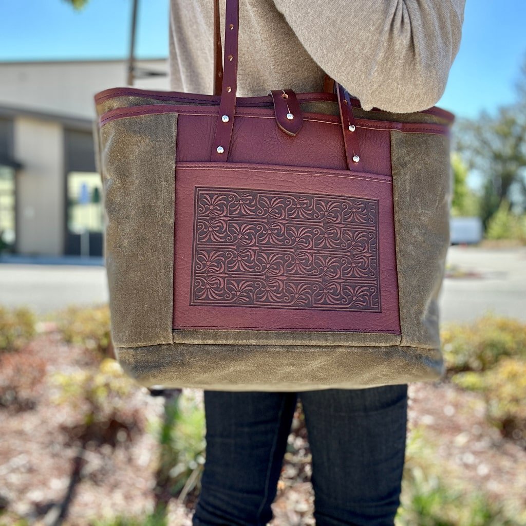 Everyday tote waxed canvas and leather Art Nouveau lattice in Tan and Wine with model in Parking Lot