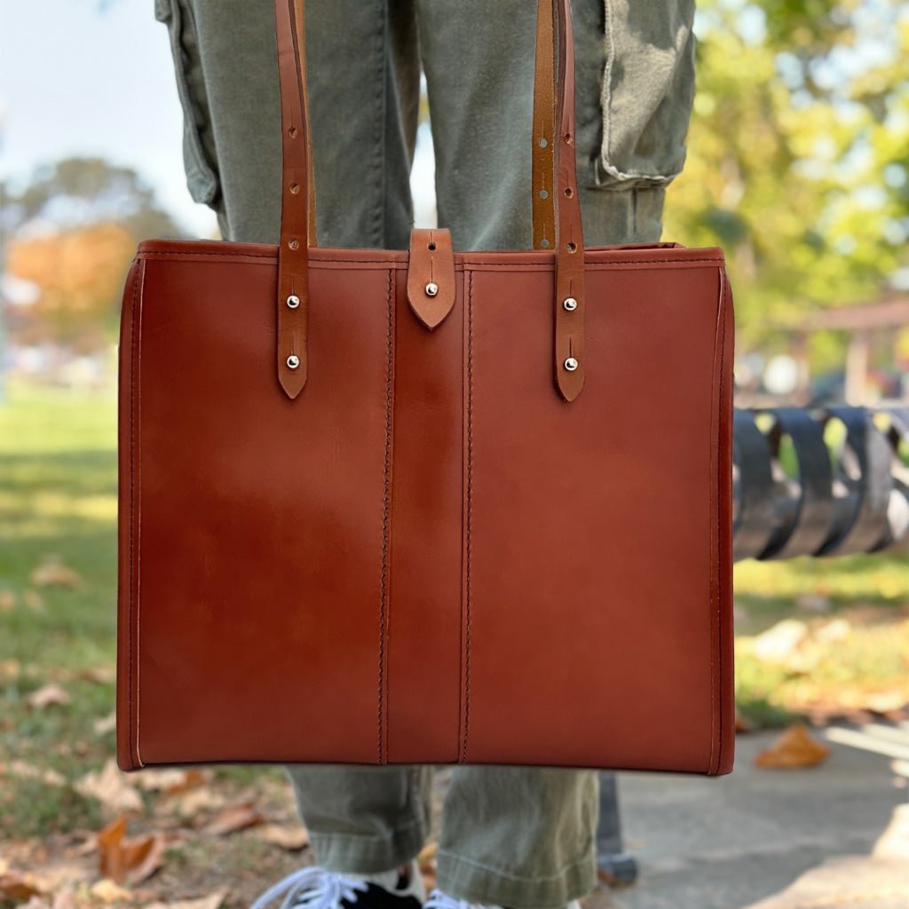 Sonoma Tote in Tahoe leather, whiskey color with model in park